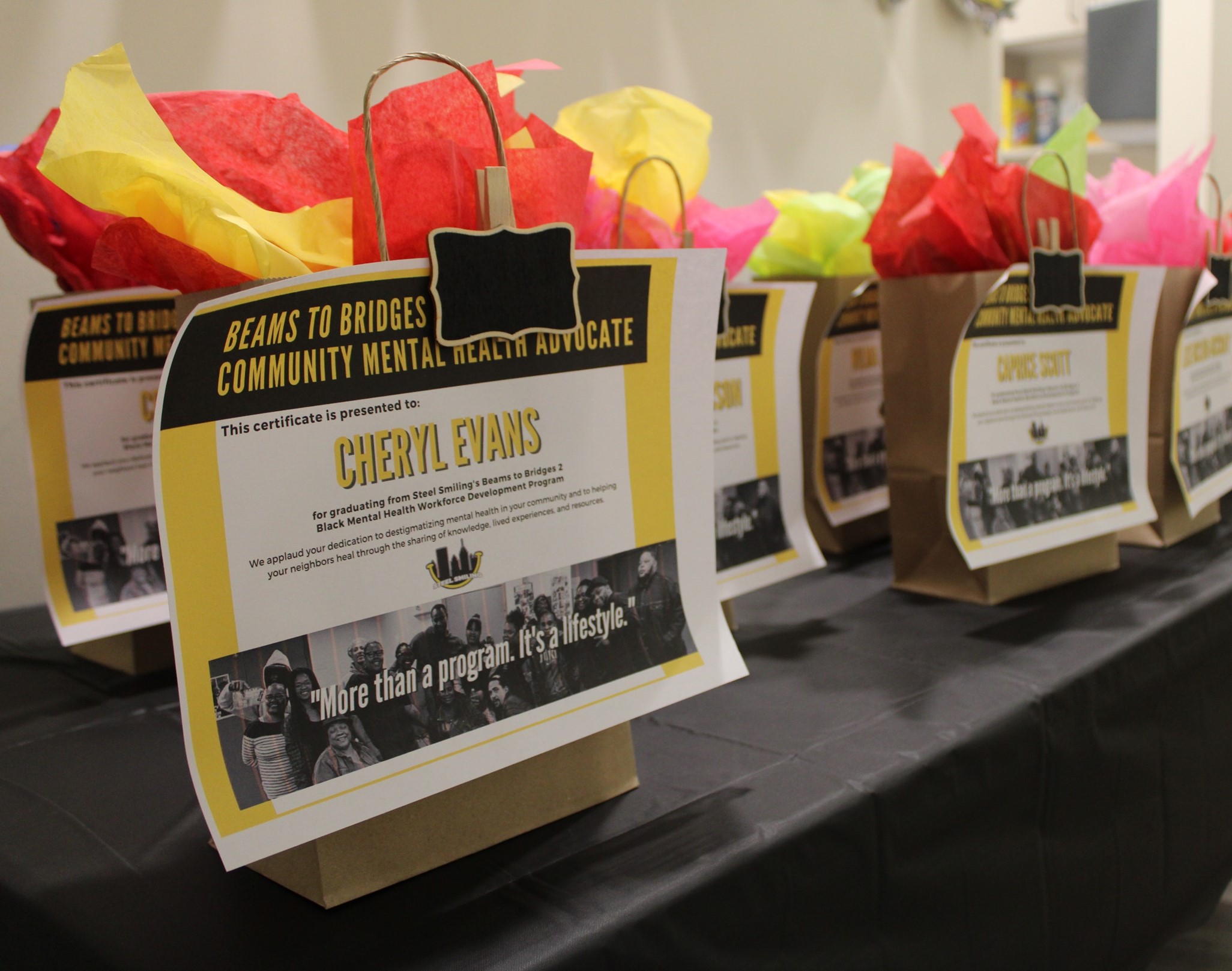 Image of gift bags with certificates on the front of them - they are for the program graduates.
