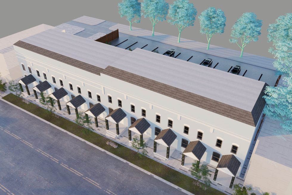 Image of a group of people walking into the current parking lot (future site of the CEA plaza). The people are walking towards the colorful mural that takes up the entire side of the CEA building.